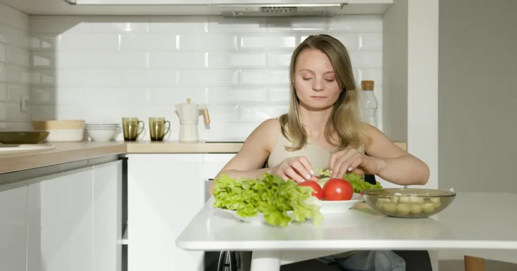 Mulher fazendo uma salada com alface e tomate