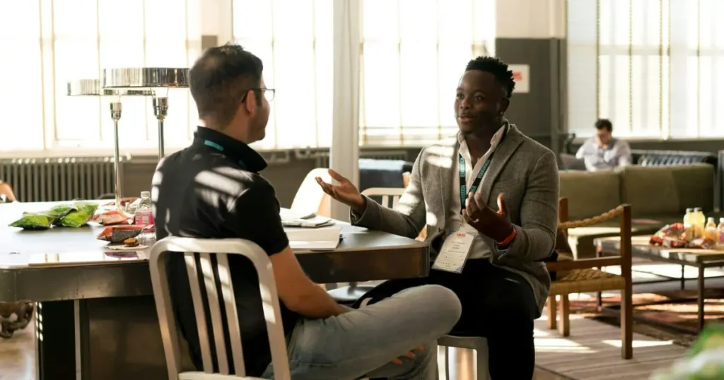 Dois homens conversando em uma sala de trabalho