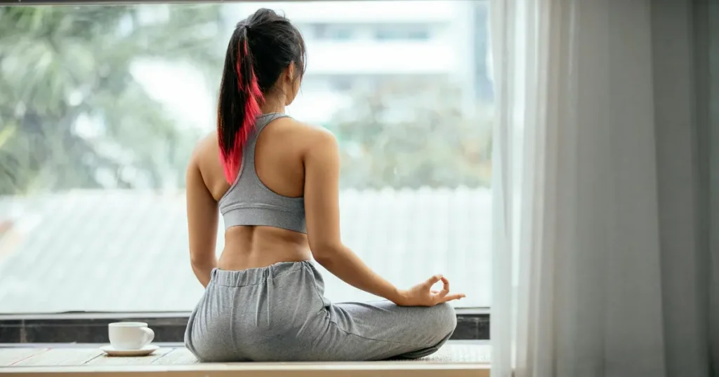 Mulher em frente a janela fazendo Mindfulness