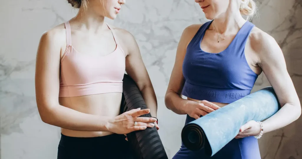 Duas mulheres conversando e segurando um tapete
