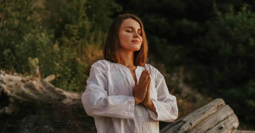 Mulher em uma floresta fazendo meditação