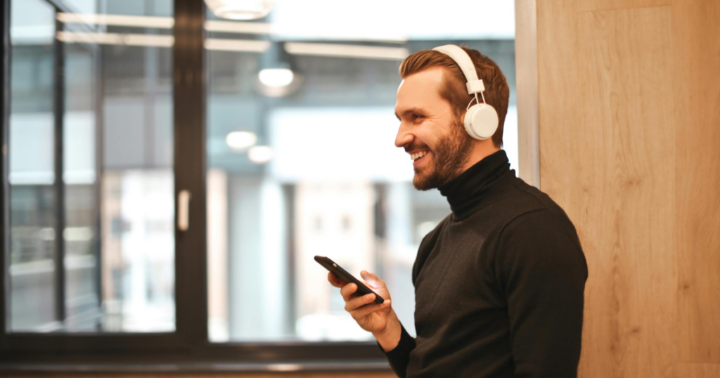 Homem sorrindo com fone de ouvido apreciando com o poder da música