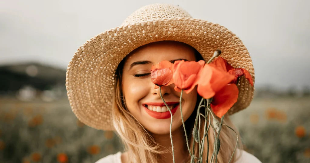 mulher sorrindo com uma flor no rosto
