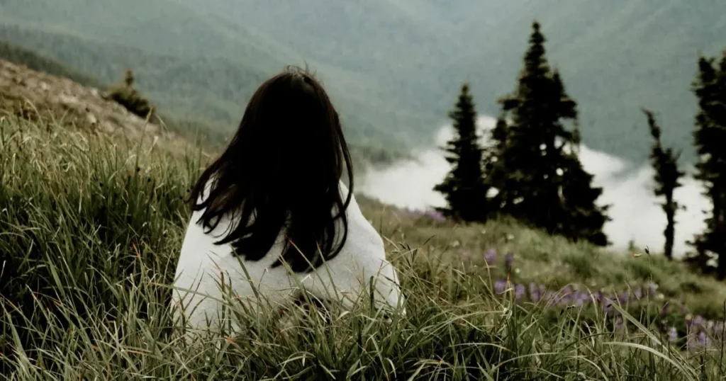 Mulher sentada em uma montanha na floresta