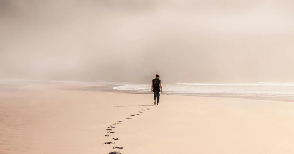 homem caminhando na praia